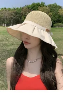 Detail of wide brim sun hat with straw crown and elegant side bow ribbon detail