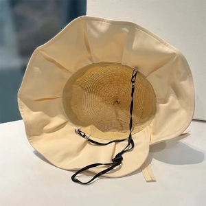 Detail of beige sun hat featuring breathable mesh lining and adjustable black chin strap