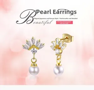 Détail des boucles d'oreilles en argent 925 plaqué or avec motif couronne et perles
