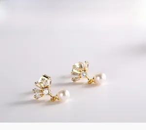 Détail de boucles d'oreilles couronne en argent 925 avec perles et pierres de zircon