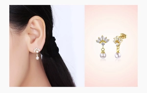 Détail de boucles d'oreilles perles en forme d'éventail avec oxydes de zirconium dorés