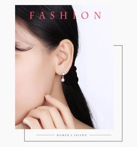 Détail de boucles d'oreilles pendantes en perles dorées portées par un mannequin de profil