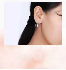 Gros plan d'élégantes boucles d'oreilles couronne en argent 925 et perle sur un mannequin