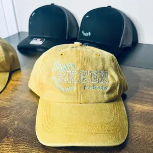 Detail of custom embroidery on yellow washed cotton baseball caps and trucker hats