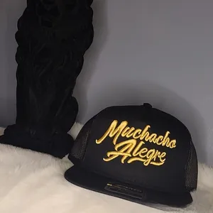 Close-up of black mesh trucker hat with 3D gold Muchacha Alegre embroidery on white fur