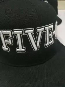 Detail of high-quality white embroidery text on a black washed cotton baseball cap