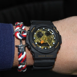 Close-up of anchor bracelet with red white blue rope and black sports watch on wrist