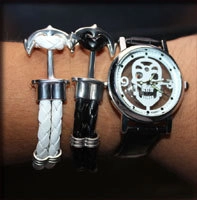 Close-up of anchor bracelet set with woven ropes and skull dial watch for couples