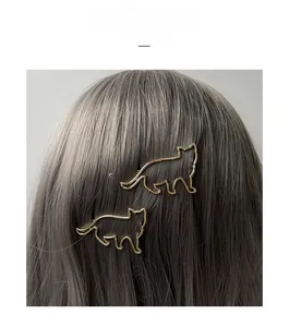 Gros plan de barrettes à cheveux dorées en forme de chat sur cheveux bruns