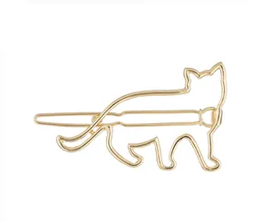 Gros plan sur la pince à cheveux dorée en forme de chat avec un design minimaliste