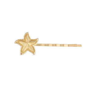 Barrette étoile de mer dorée en alliage avec texture bionique sur fond blanc