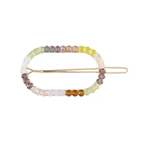Detail showing colorful beaded hair clip with golden finish and faceted crystals