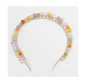 Detail of thin gold headband with colorful translucent glass beads in various bright tones