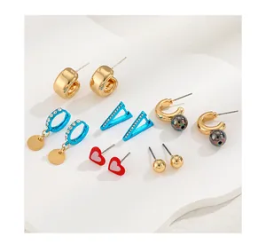 Detail view of 6-pair geometric earring set featuring gold hoops and colorful resin charms