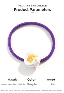 Detail of purple hair tie with white pearl bead featuring a golden Yin Yang symbol