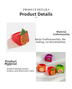Detail of colorful resin rings featuring tropical fruit designs and crystal accents