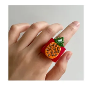 Close-up of tropical fruit resin ring featuring a pineapple motif with small rhinestones