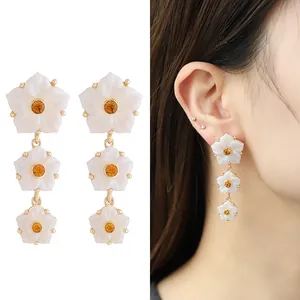 Boucles d'oreilles pendantes fleurs en résine blanche avec cœur doré et modèle