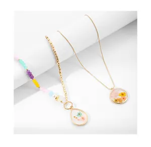 Gros plan de pendentifs en résine avec de véritables fleurs séchées colorées incrustées