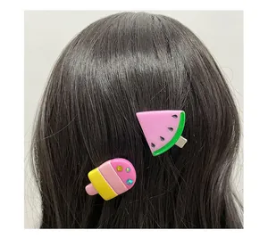 Detail showing watermelon and popsicle hair clips worn on long brown hair in a summer set