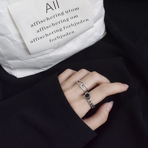 Detailed view of layered S925 silver twist ring and vintage black gemstone chain ring