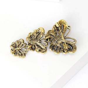 Elegant vintage butterfly brooch with rhinestones and antique gold finish shown on white base