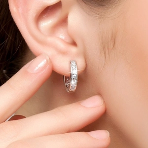 Elegant silver hoop earrings with micro-pave white zircons shown on a model's ear