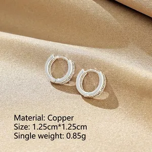 Minimalist copper hoop earrings with 7 micro-pave zircons on champagne satin background