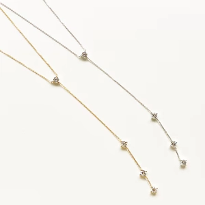 Elegant gold and silver tassel necklaces with rhinestones for parties on white backdrop