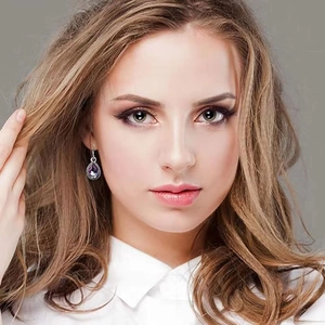 Elegant purple teardrop crystal earrings with diamond halo shown on a fashion model