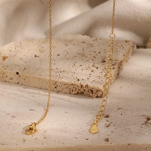 Detail shot of the S925 sterling silver stamp on the gold lobster clasp and extender chain