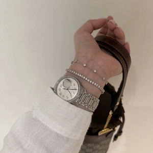 Detail of silver tennis bracelet set with iced out rhinestones on a female wrist