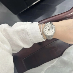 Close-up of a silver rhinestone watch and matching tennis bracelet on a model wrist
