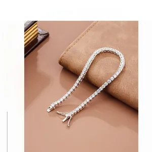 Detail of a sparkling tennis bracelet with square-cut zircons on a leather surface