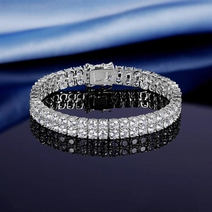 Macro detail of double-row tennis bracelet with sparkling stones on blue silk fabric