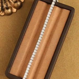 Macro shot of single-row tennis bracelet with claw-set round cubic zirconia in luxury box