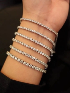 Close-up of sparkling stacked tennis bracelets featuring brilliant round-cut stones