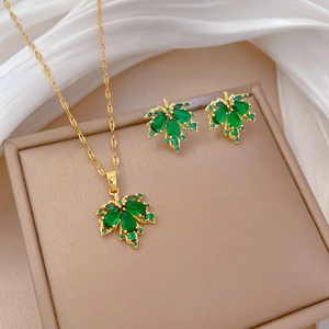 Detailansicht des goldenen Ahornblatt-Schmucksets mit grünen Zirkonia-Steinen