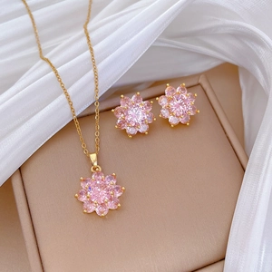 Detailed view of pink flower jewelry set featuring gold necklace and stud earrings