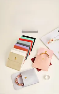 Various macaron-colored leather jewelry pouches with snap buttons for rings and bracelets