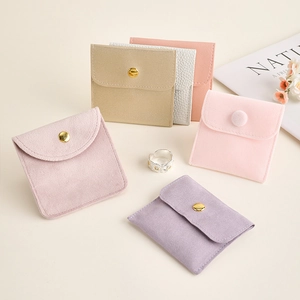 Pastel plush jewelry pouches in velvet and faux leather with gold snap buttons