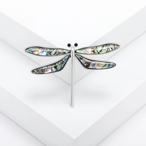 Elegant silver dragonfly brooch with iridescent abalone shell wings on white pedestal