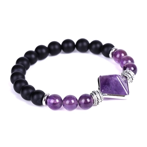 Detail of matte black onyx beads and faceted amethyst pyramid stone on a beaded bracelet