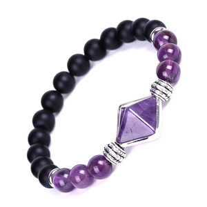 Macro shot of natural amethyst octahedron pendant and matte onyx beads on the bracelet