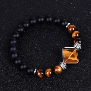 Macro view of matte black onyx and tiger eye beads with vintage silver spacer on bracelet