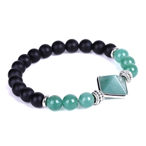 Detailed macro view of black matte onyx beads and green crystal pyramid pendant bracelet
