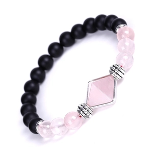 Detailed macro view of matte black agate beads and pink quartz stone on a crystal bracelet