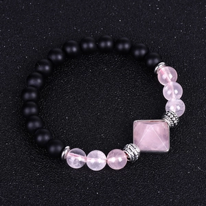 Macro shot of matte black onyx beads and rose quartz centerpiece on a beaded bracelet