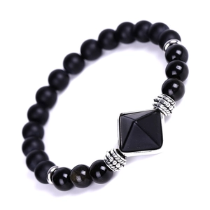 Detail of matte black onyx beads and pyramid pendant on a minimalist beaded bracelet