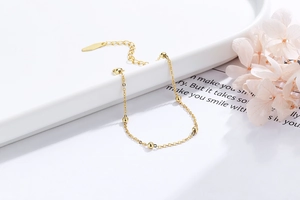 Macro shot of gold-plated silver bead bracelet with polished spheres and extender chain